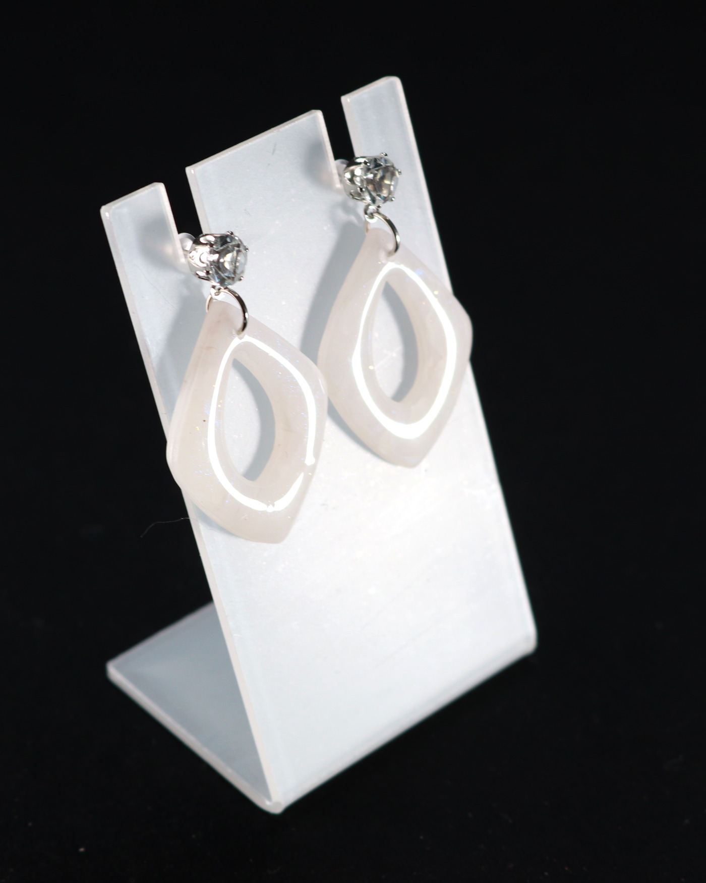 Ivory sculptural earrings on a luxe display stand